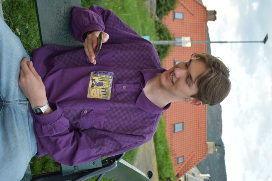 Dennis smiler mens han ser på mobilen